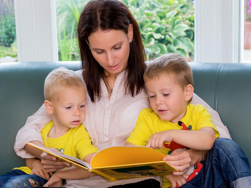 Små børn der læser sammen med en voksen